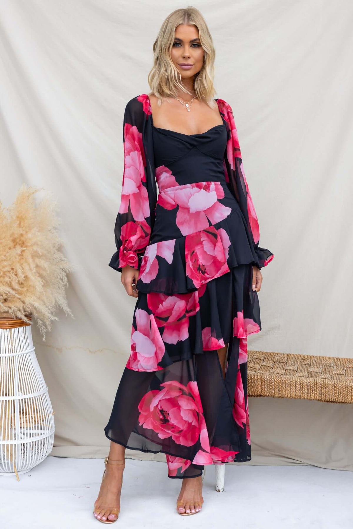 Kameryn Maxi Dress in black chiffon with pink floral design, featuring elastic sleeves and front split, worn by model.