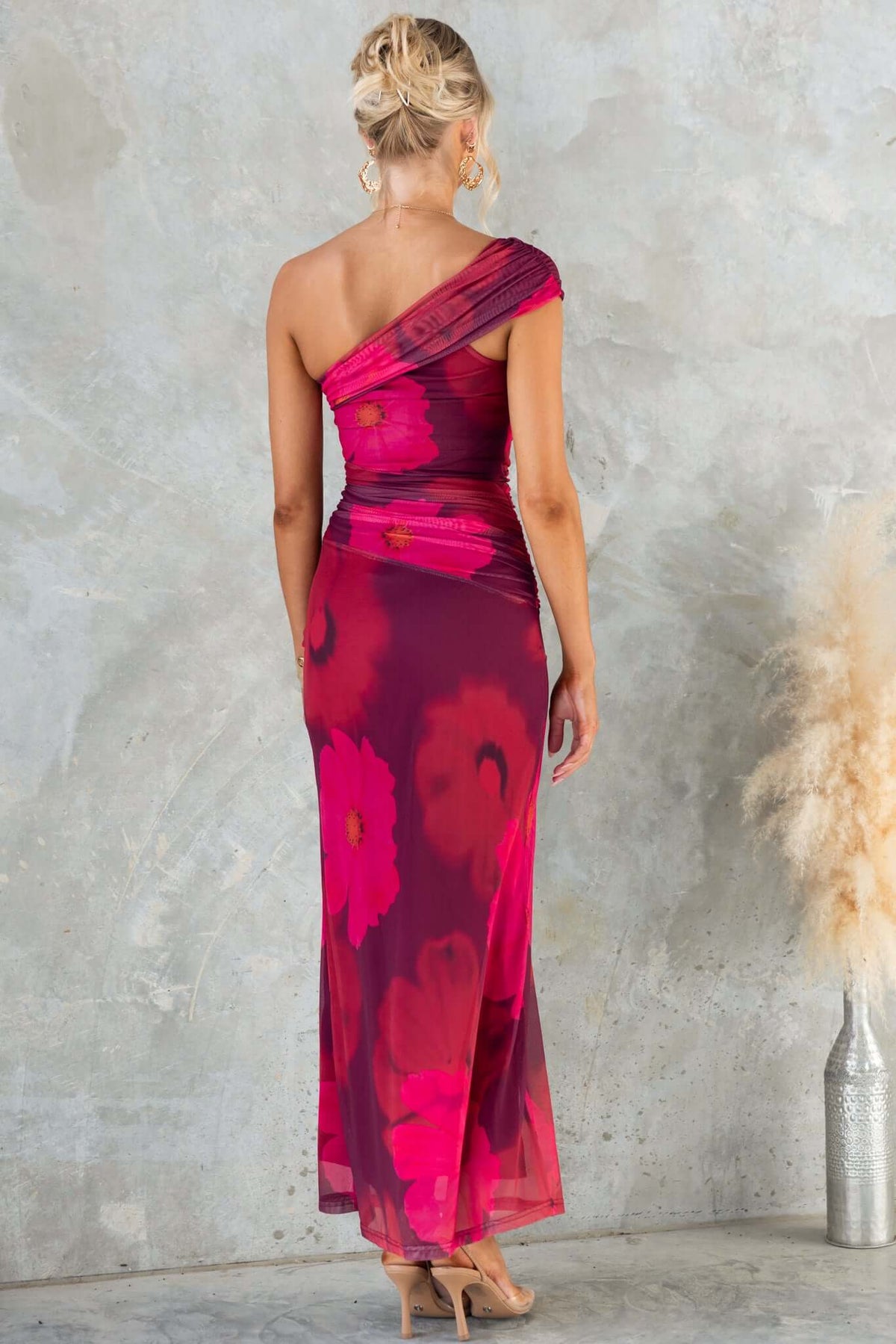 Back view of the Korren Maxi Dress featuring a one-shoulder neckline and vibrant floral print in pink and purple.
