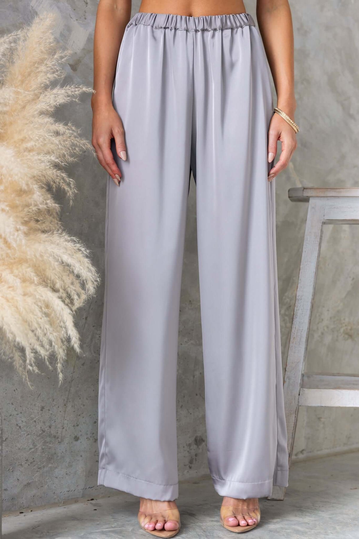 Kortez Pants in soft satin material, featuring a mid-high waist, elastic waistband, and pockets for a stylish look.