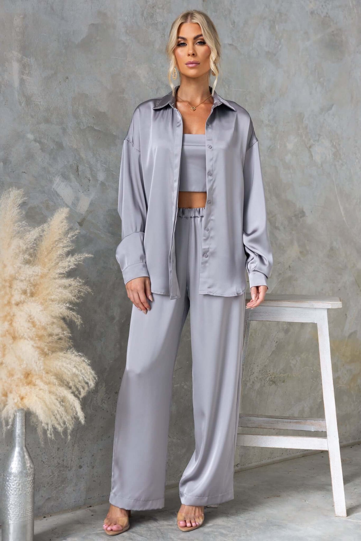 Model wearing a Kortez Shirt in satin gray with a button-up front, paired with matching satin pants, on a stylish background.
