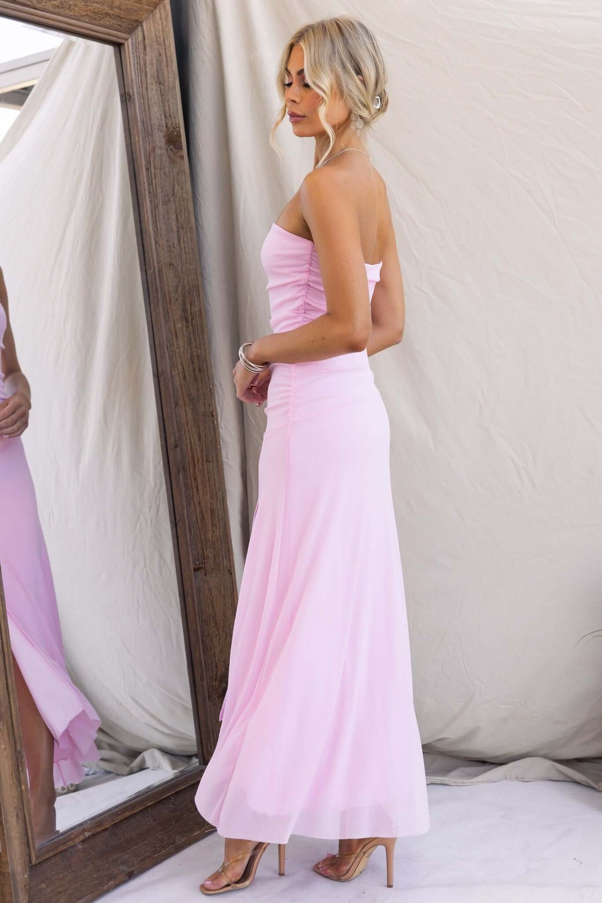 Elegant strapless pink maxi dress with anti-slip bust and front split, showcased in a mirror reflection.