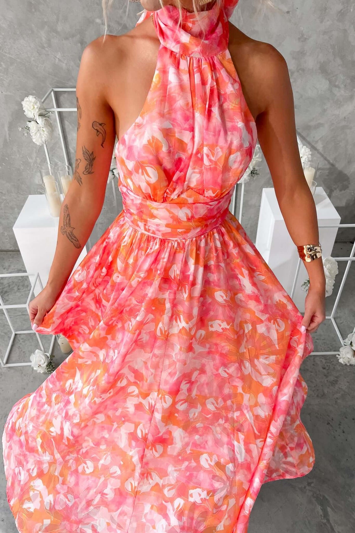 Model wearing the Little Things Maxi Dress, featuring a high tie neckline and vibrant floral pattern.