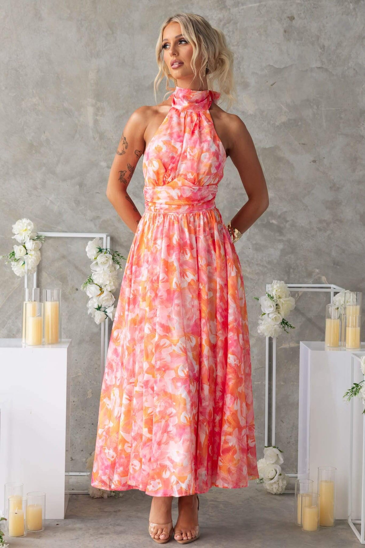 Model wearing the Little Things Maxi Dress with a high tie neckline and floral design, styled with soft lighting.