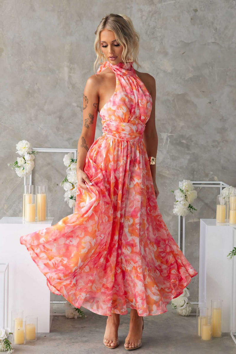 Model wearing Little Things Maxi Dress with high tie neckline in pink floral pattern, showcasing elegant flow and fit.