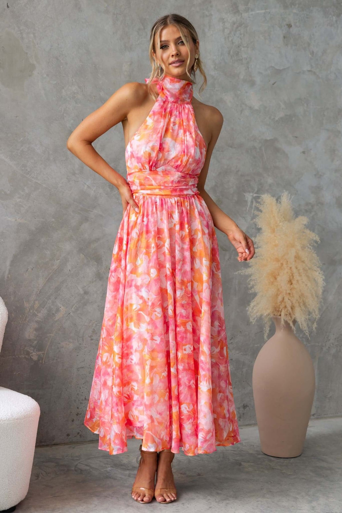 Model wearing the Little Things Maxi Dress with a high tie neckline and floral print, perfect for warm weather occasions.