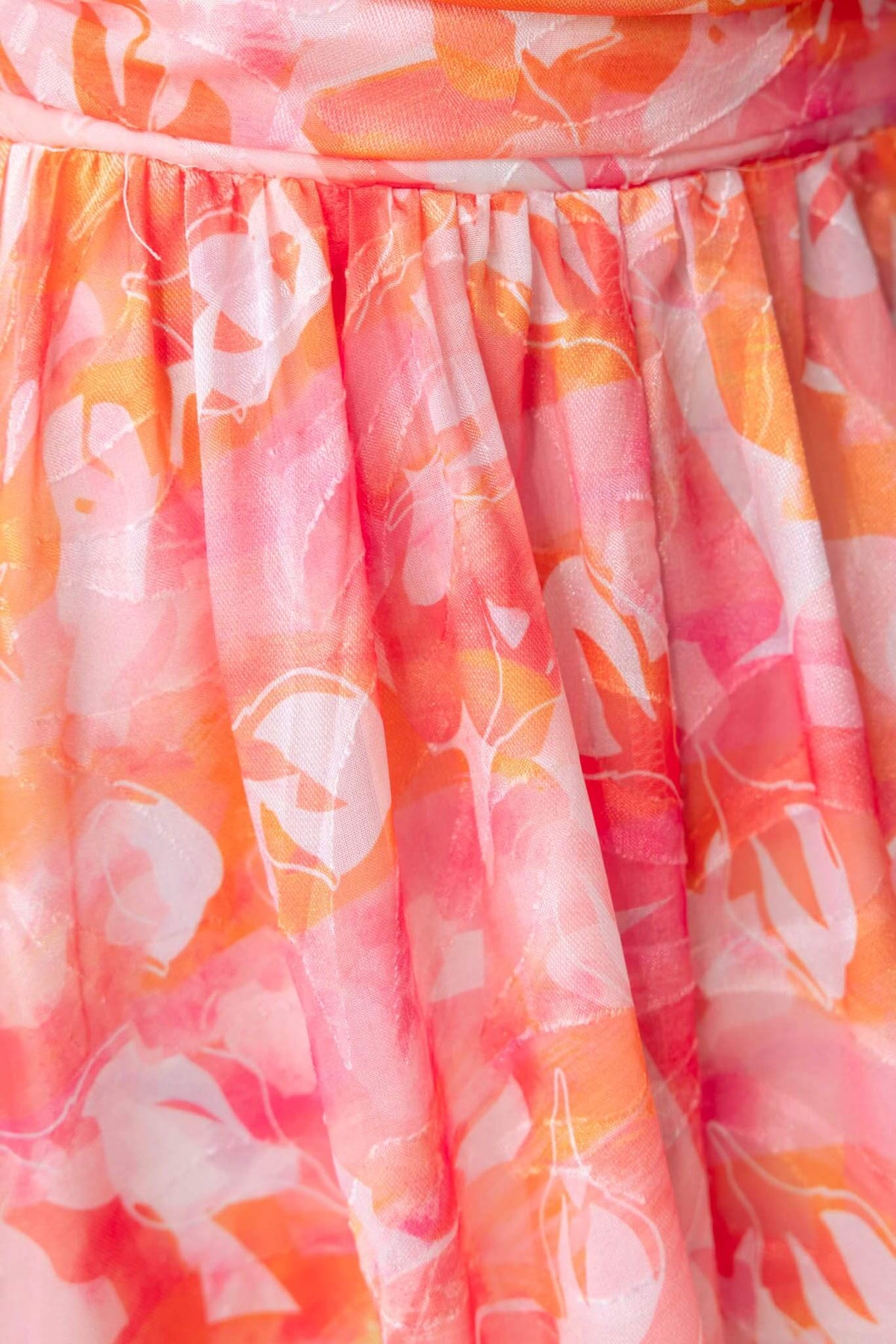 Close-up of the vibrant pink floral fabric of the Little Things Maxi Dress, showcasing its beautiful draping and pattern.