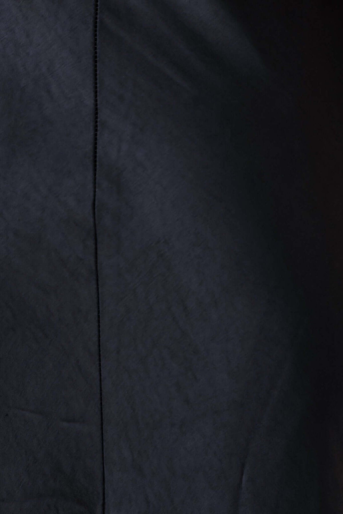 Close-up of the smooth fabric texture of the black Locust Maxi Dress, highlighting its elegant design.