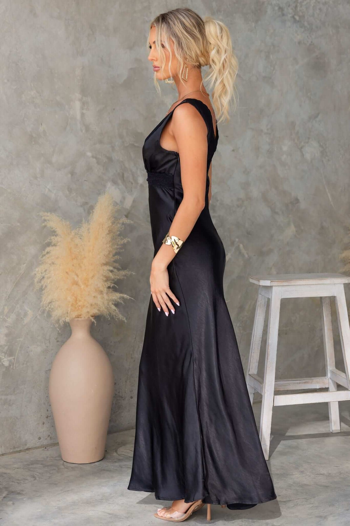 Side view of a black Locust Maxi Dress featuring a V-neckline and sleek silhouette.