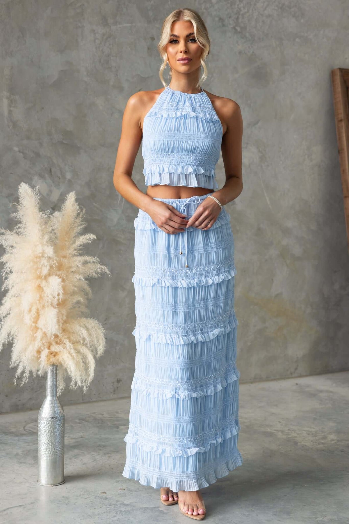 Model wearing a light blue Lolana Maxi Skirt with matching crop top, showcasing ruffled details and a stylish fit.