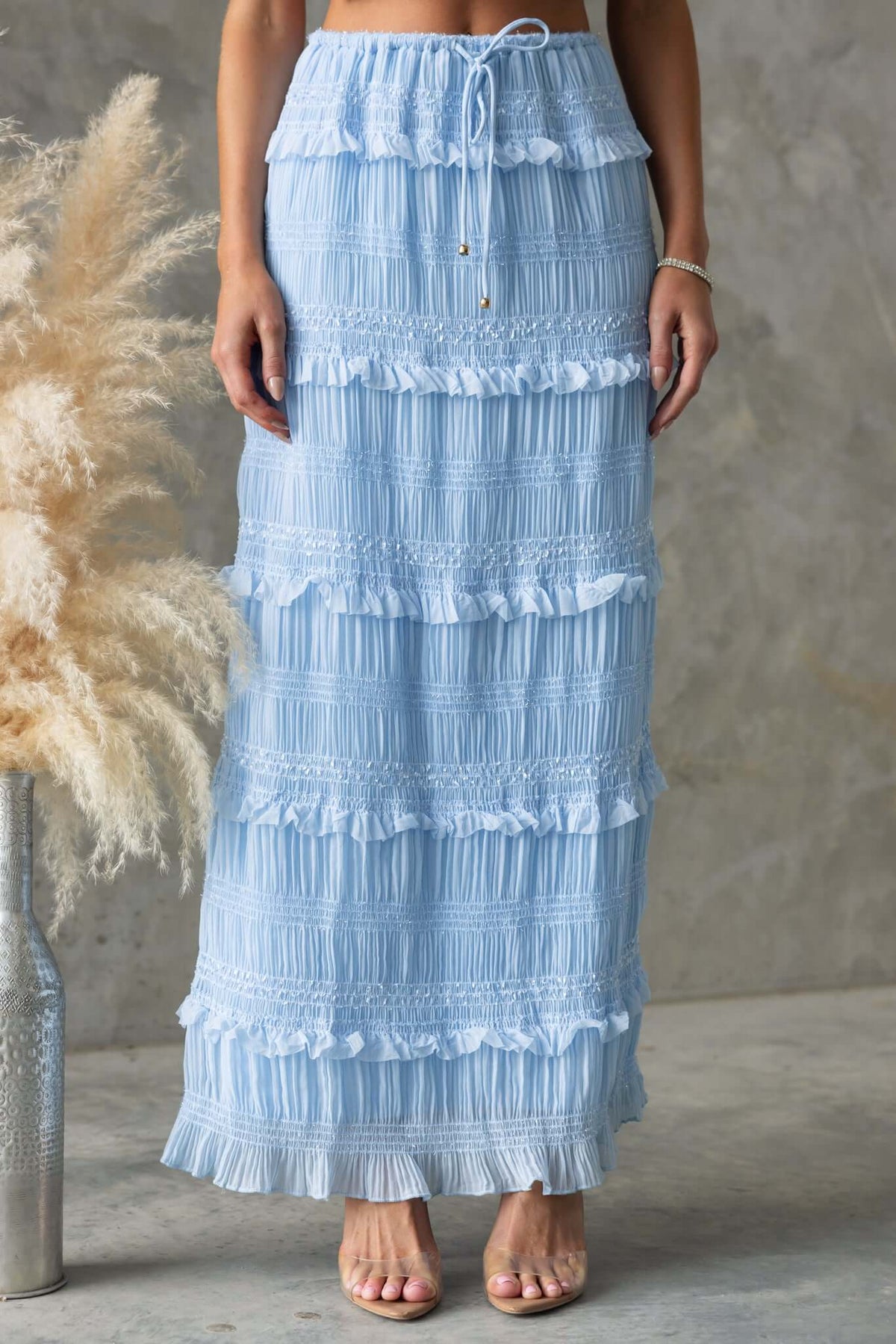 Light blue Lolana maxi skirt with ruffles, elastic waistband, and drawstring, perfect for stylish summer outings.