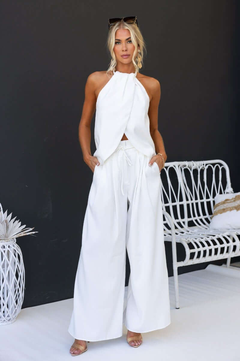 Model wearing Long Shot Pants in white with paperbag waist, removable tie, and wide-leg fit, showcasing stylish casual wear.