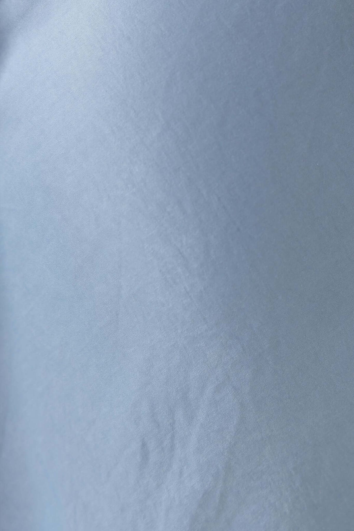 Light blue fabric texture with slight sheen, ideal for creating stylish and elegant garments.