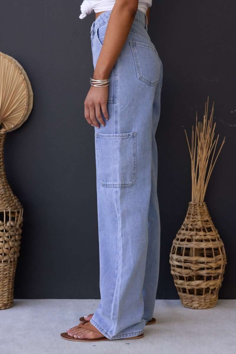 Side view of Madrid Jeans, mid-high waist cargo style denim with pockets, featuring a relaxed fit.