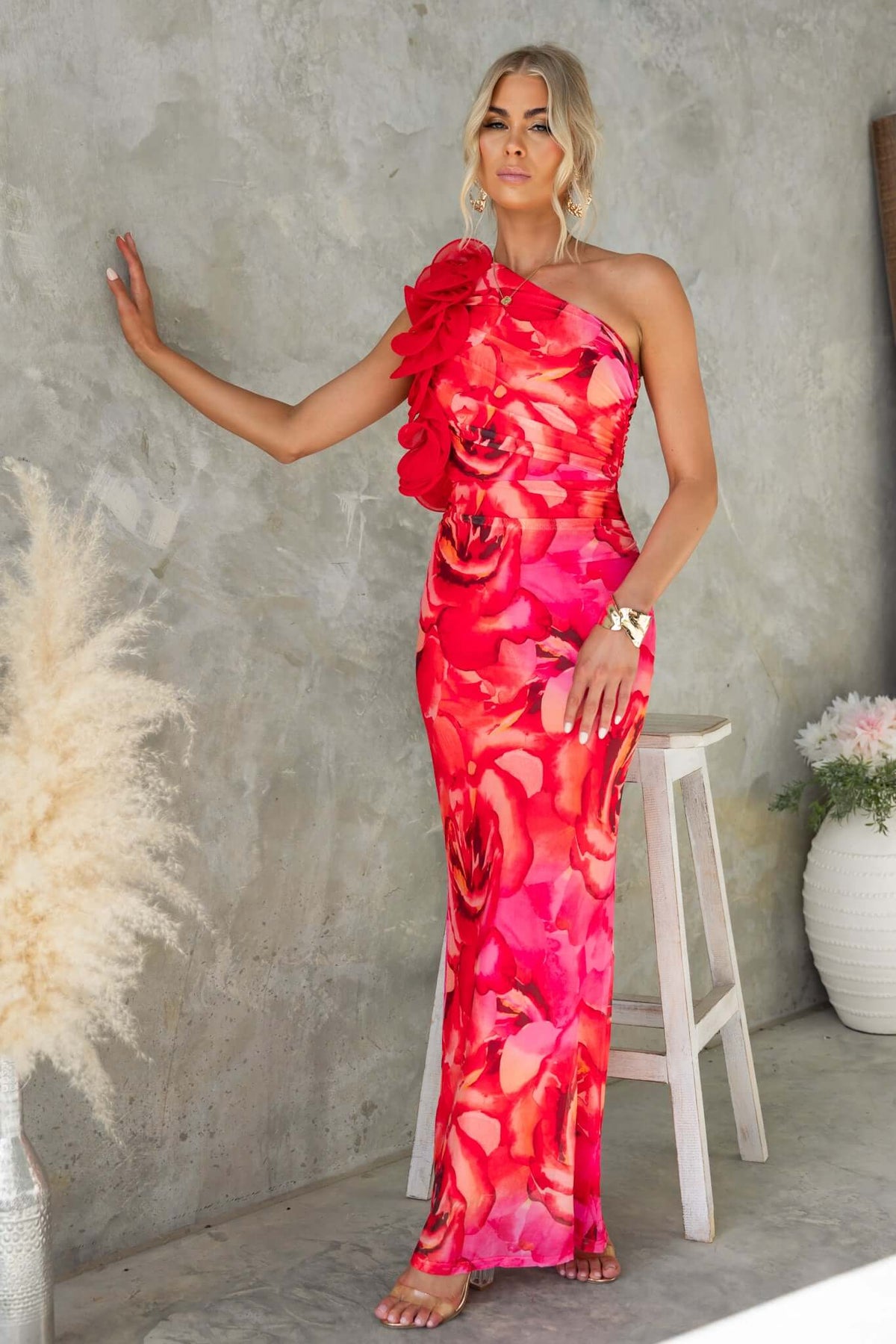 Model wearing Meriden Maxi Dress with one-shoulder neckline and floral design in vibrant pink hues.
