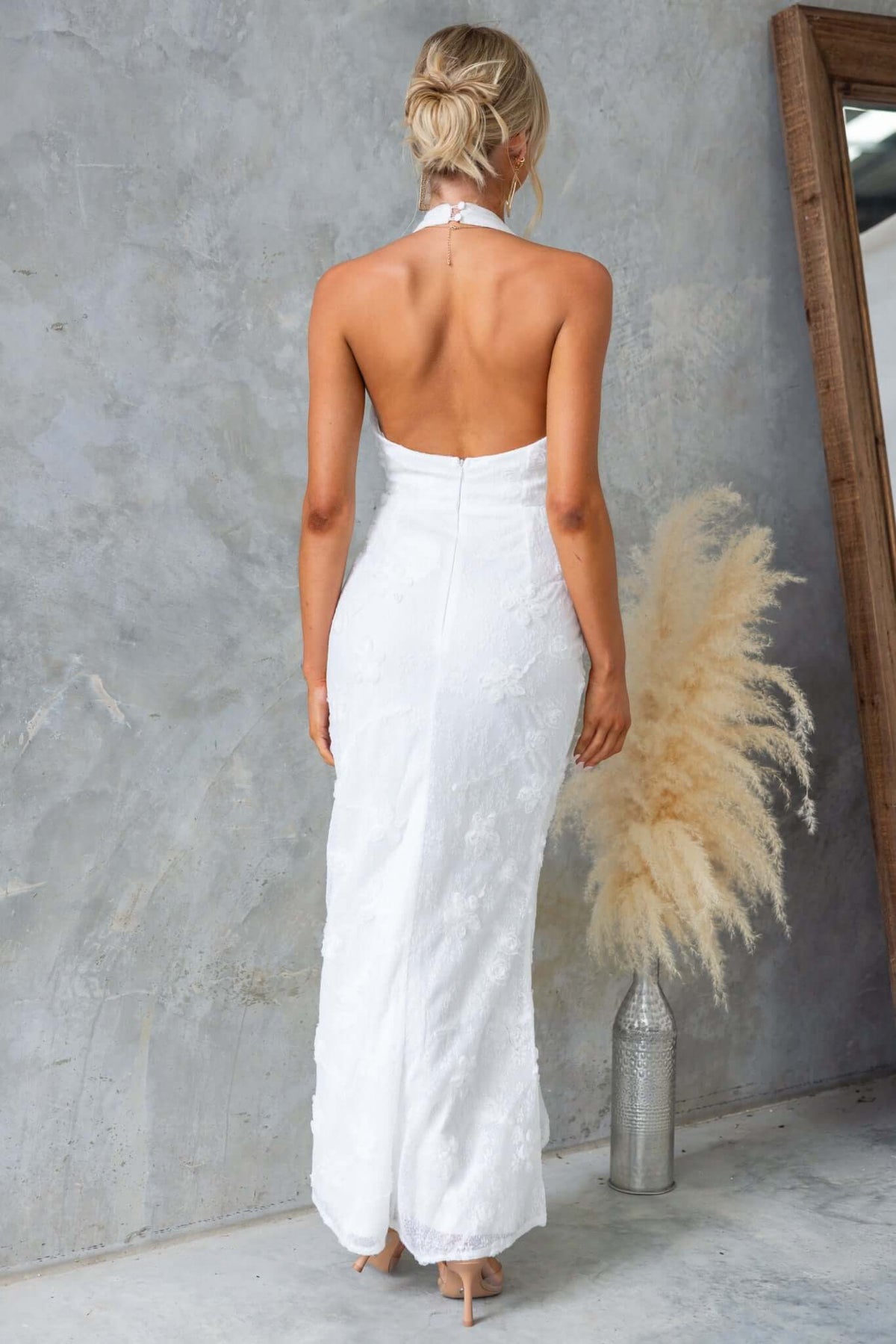 Back view of Metrick Maxi Dress by Amaroso Bridal, featuring a halter neckline and fishtail hem.