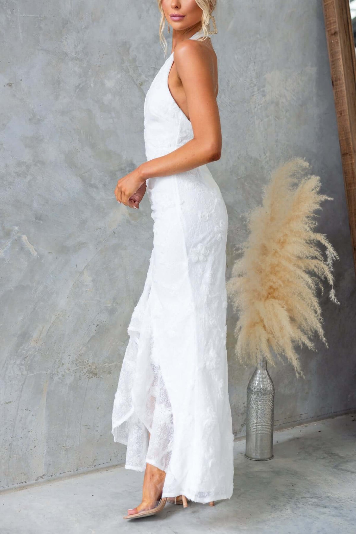 Model wearing Metrick Maxi Dress with halter neckline and fishtail hem, showcasing textured fabric and stylish design.