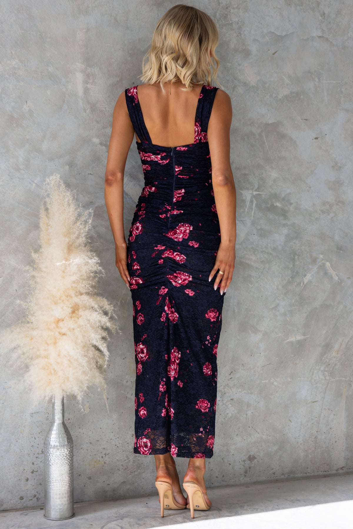 Back view of Xavina maxi dress in navy with floral print, showcasing twist detail and ruching.