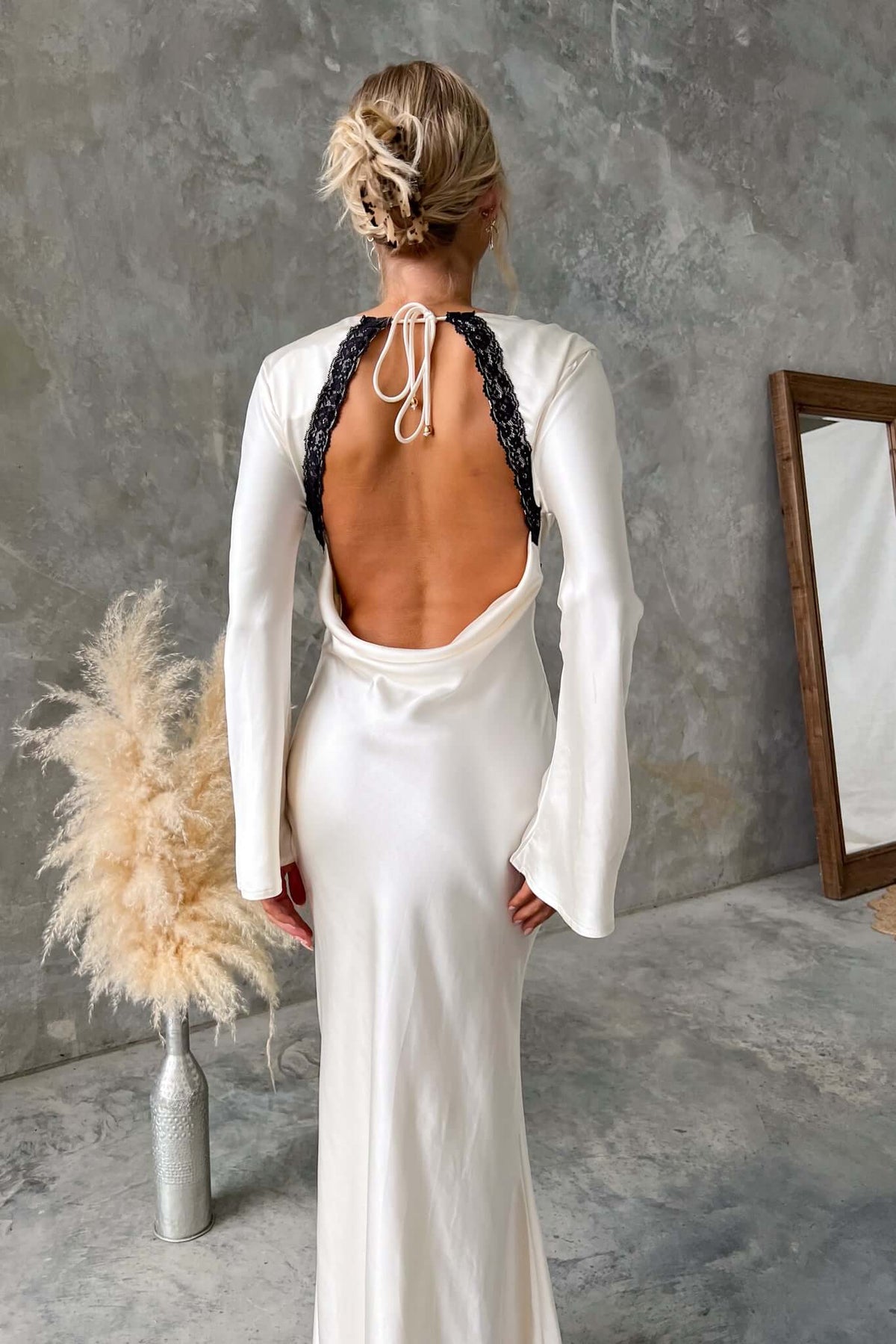 Back view of Nicholie Maxi Dress with lace detail and tie at the back, showcasing elegant draping and a flattering fit.