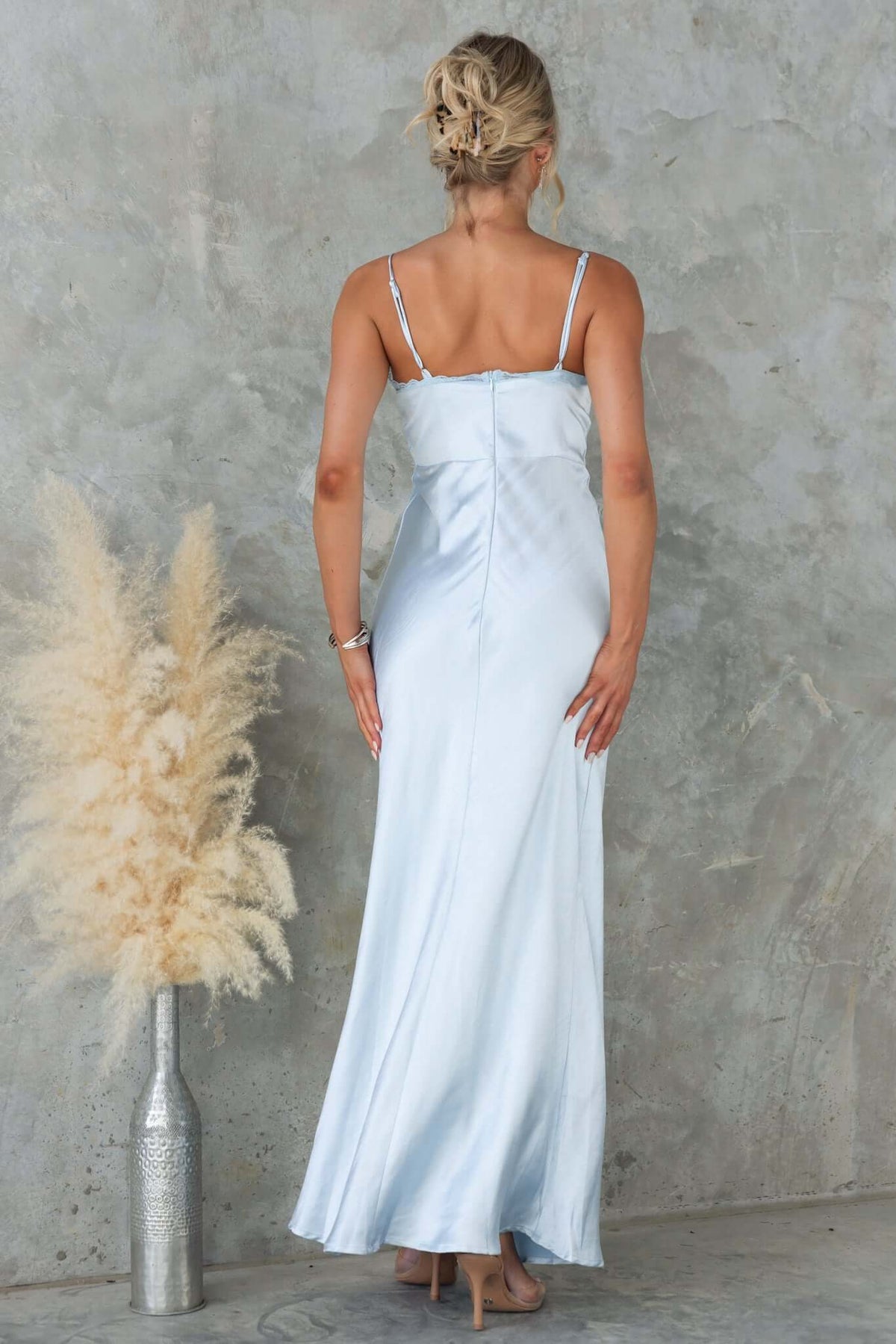 Back view of a woman in a light blue Obsidian Maxi Dress with adjustable straps and lace panel.