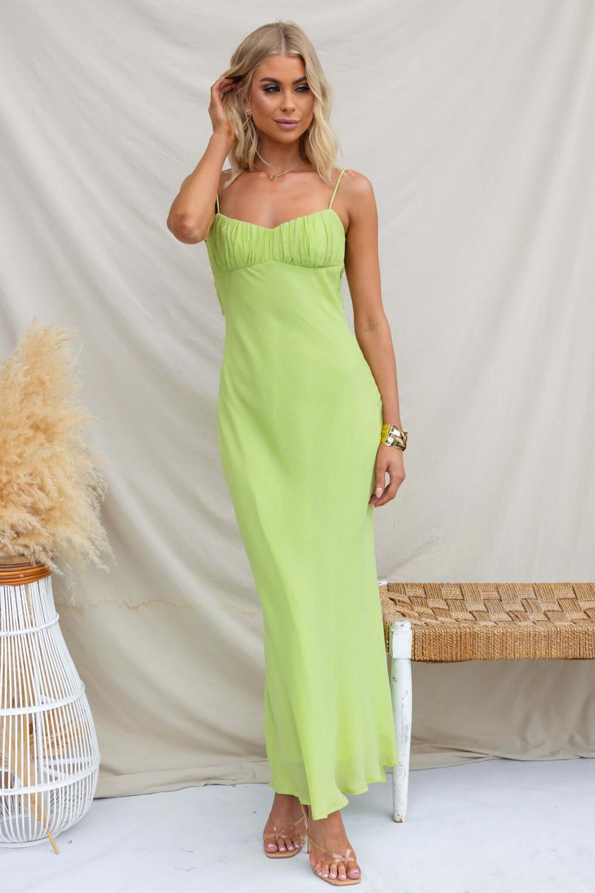 Model wearing a vibrant green Orinthia Maxi Dress with adjustable straps and gathered bust detail.