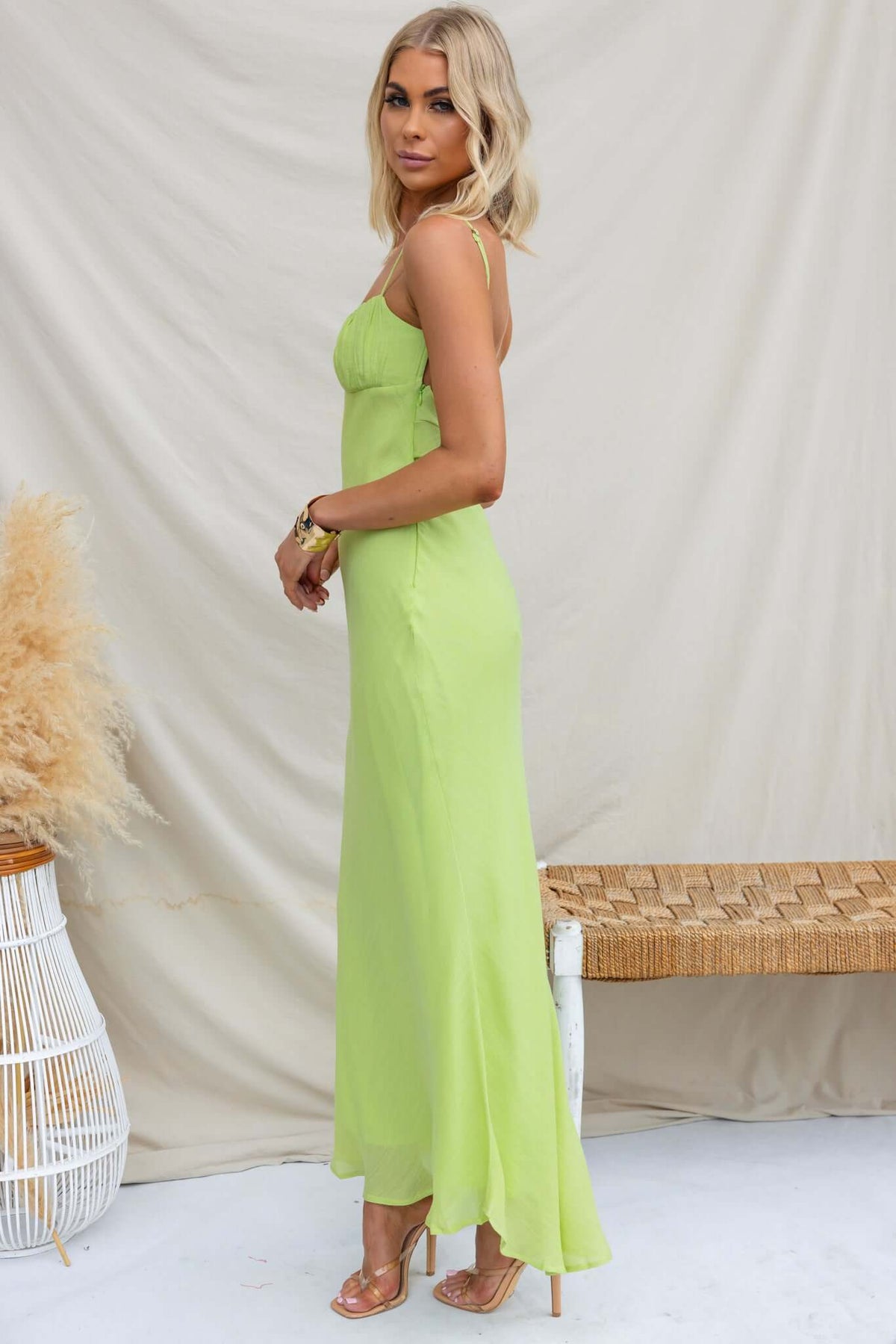 Model wearing Orinthia Maxi Dress in vibrant green, featuring adjustable straps and elegant chiffon material.