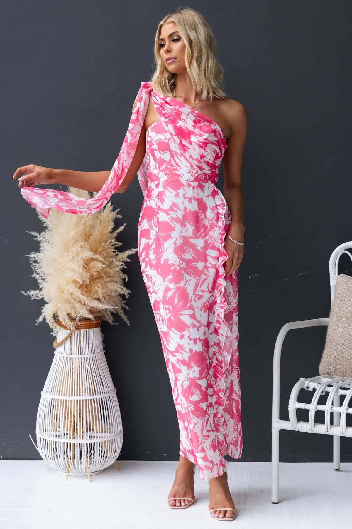 Strapless pink floral maxi dress with a side split and attached tie, showcasing elegant summer fashion.
