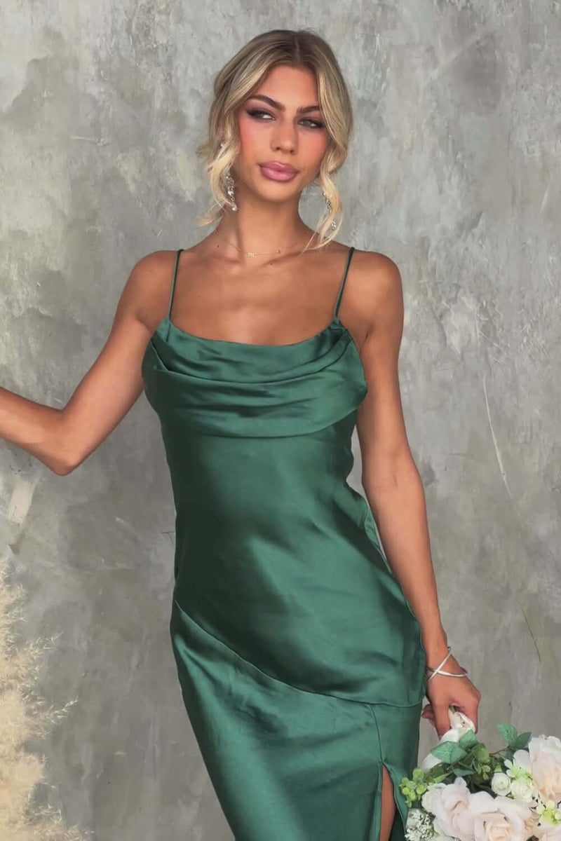 Elegant woman in a green satin midi dress with adjustable straps and front slit, showcasing bridal fashion.