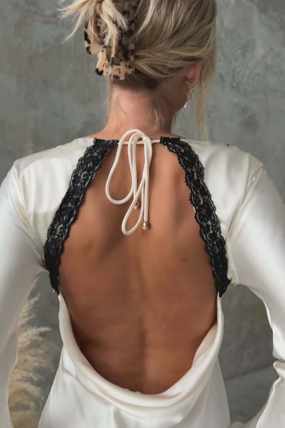 Back view of Nicholie Maxi Dress showcasing lace detail and tie closure in elegant bridal design.