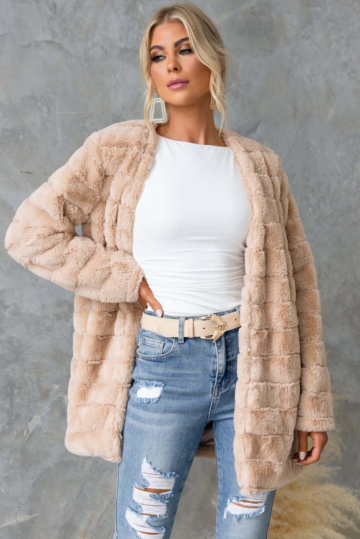 Quentin faux fur jacket in beige, featuring hook & eye closure, worn by a model styled with distressed jeans.