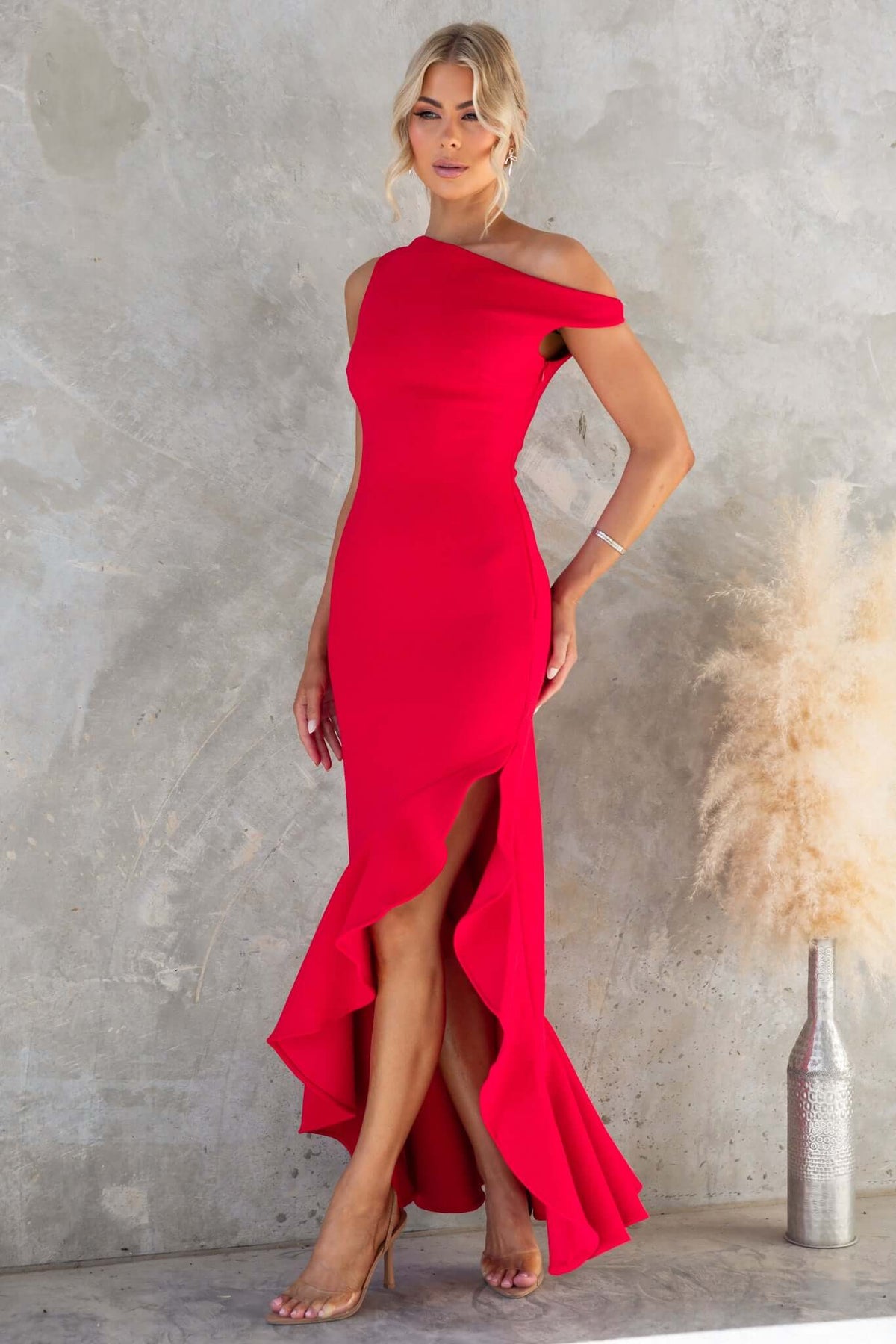 Raleigh Maxi Dress in red with asymmetric neckline and hem, featuring a side slit and elegant silhouette.