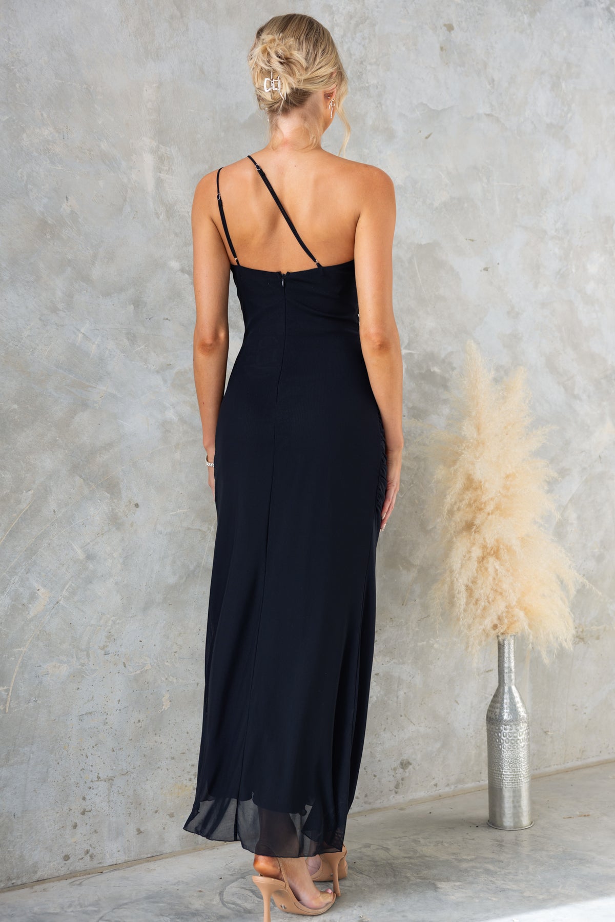 Rehna Maxi Dress with one-shoulder neckline and adjustable straps, featuring a high-low hem in black mesh fabric.