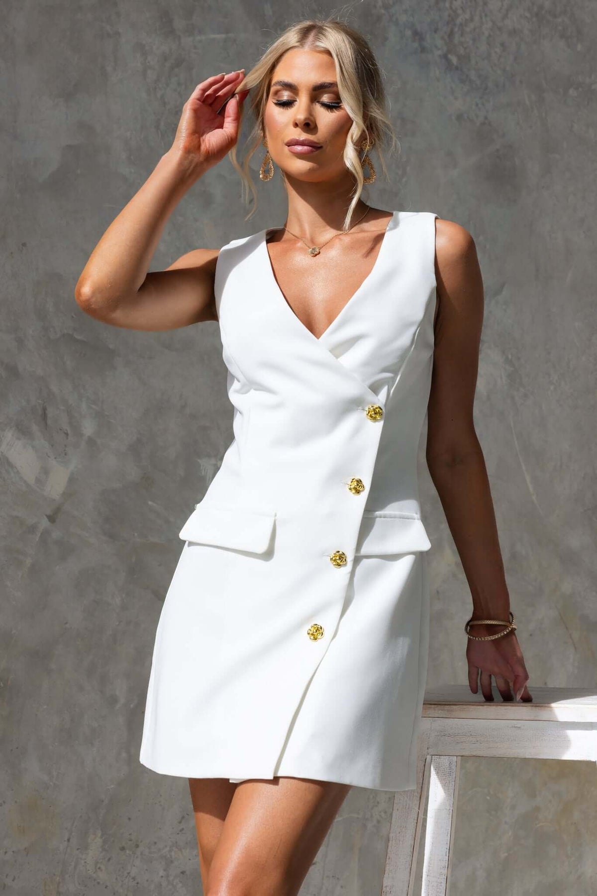 Rhode Dress featuring a V-neckline, button-up front, and a stylish lined design in white.