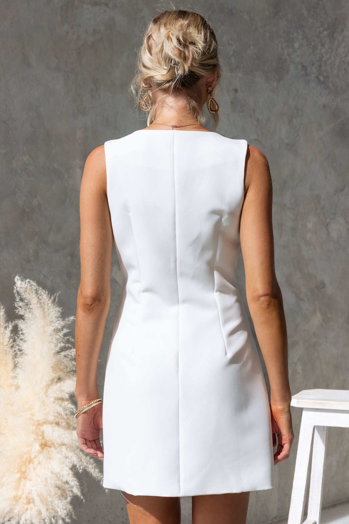 Back view of a stylish white dress showcasing a sleek design and fitted silhouette, perfect for any occasion.
