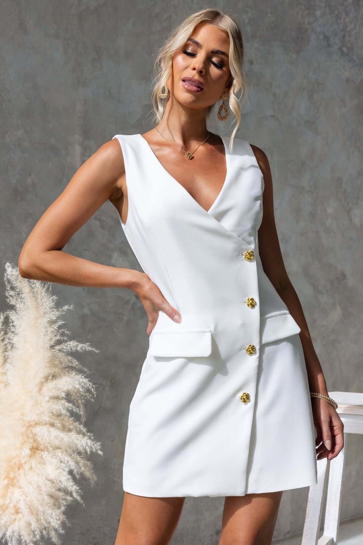 Rhode Dress featuring a V-neckline, button-up front, and a stylish white design, perfect for trendy summer outfits.