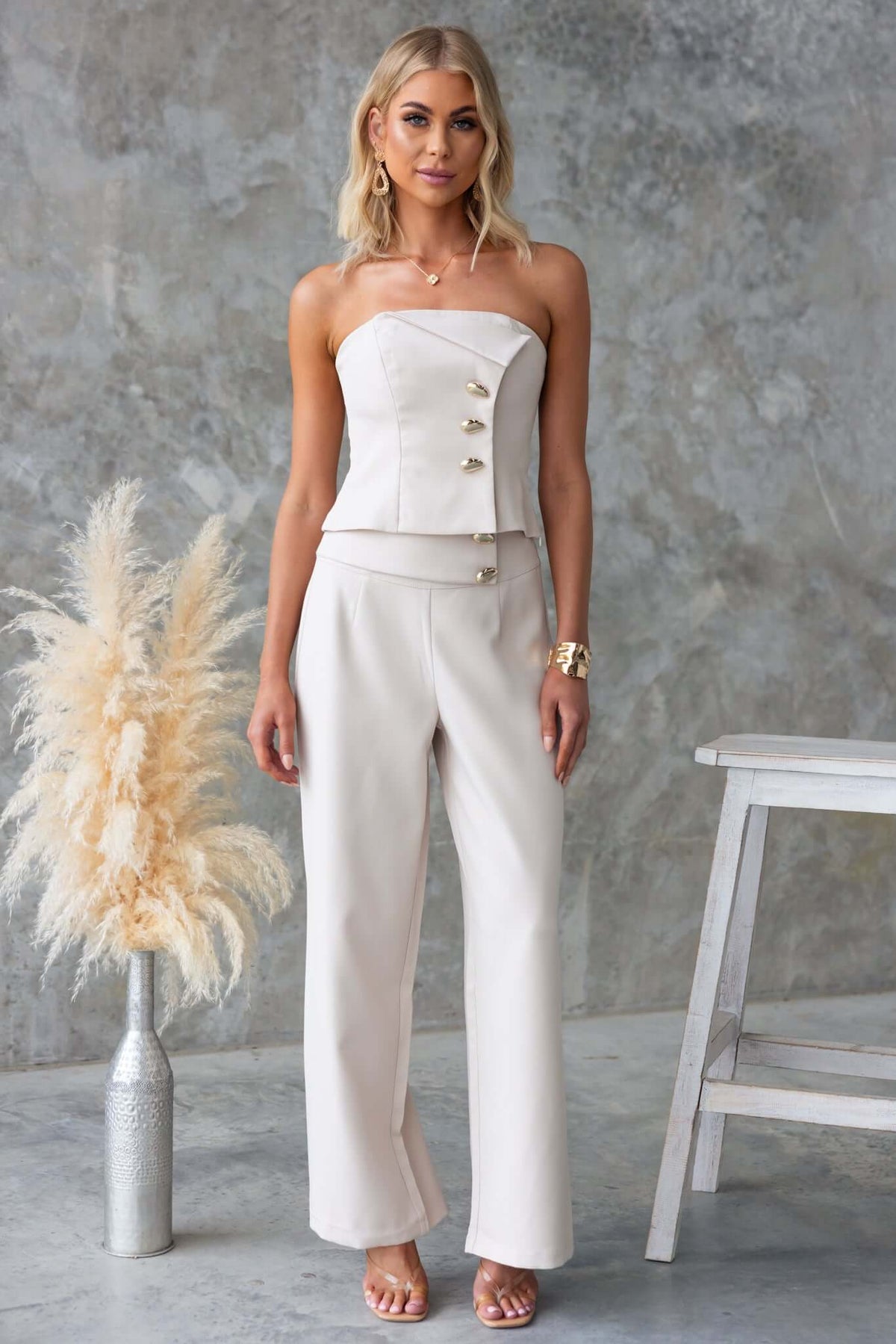 Stylish model wearing Roan Pants paired with a strapless top, featuring faux buttons and a mid-high waist fit.