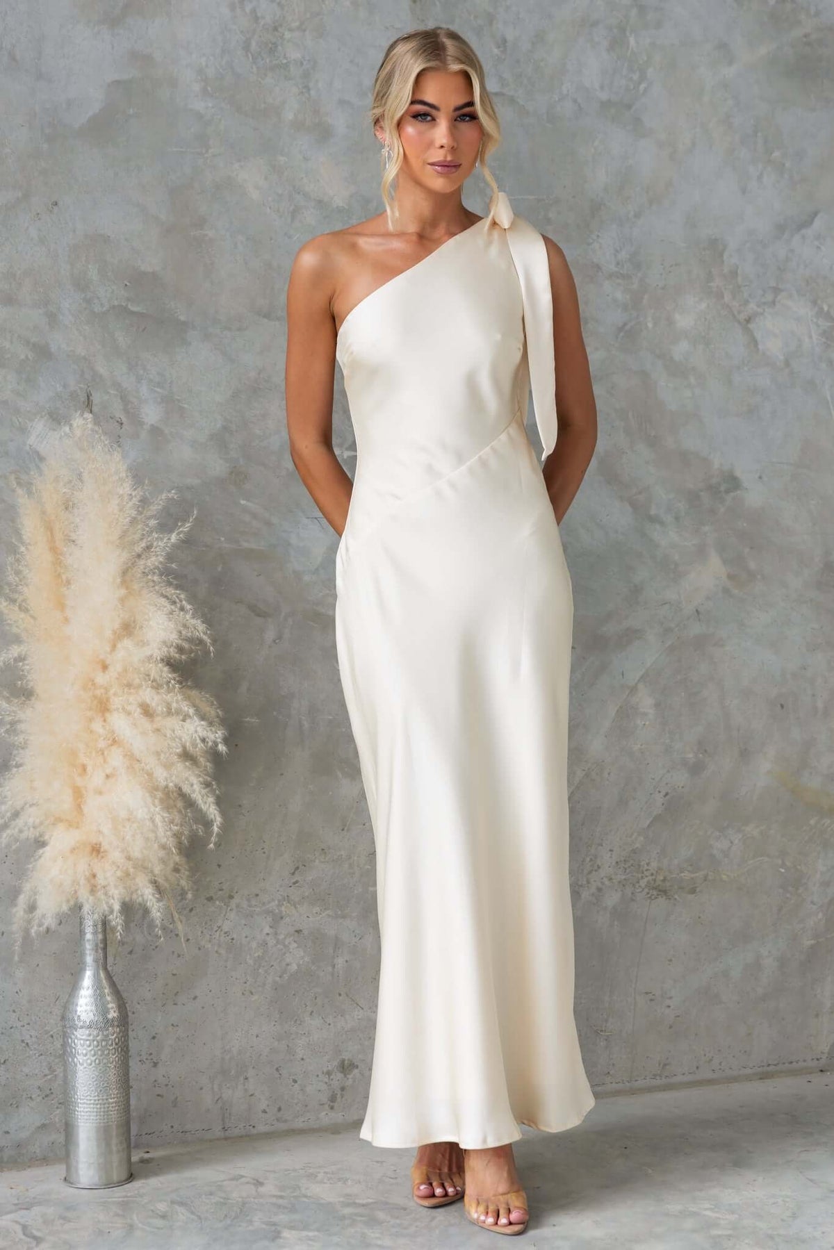 Ronnie Maxi Dress by Amaroso Bridal, one-shoulder satin gown with a tie neckline, perfect for elegant occasions.