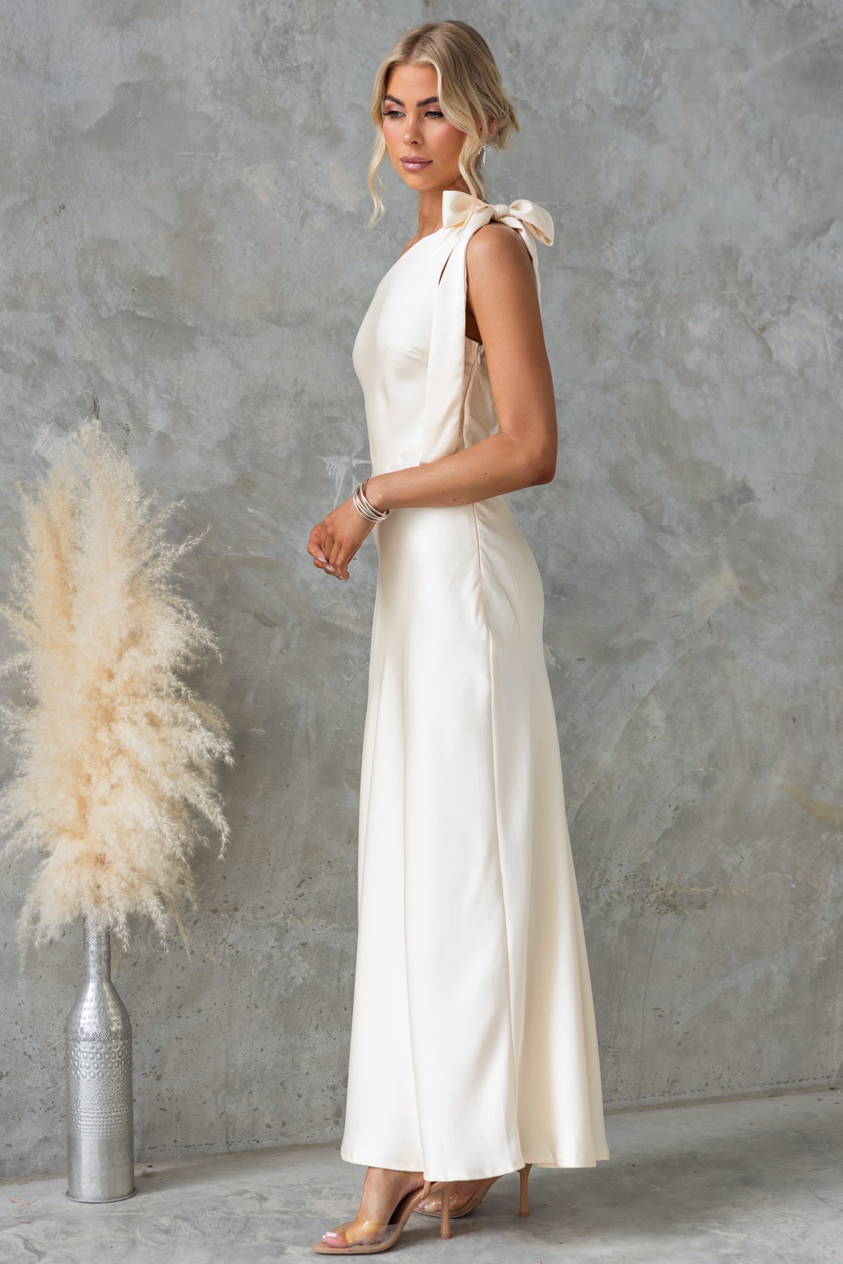 Ronnie Maxi Dress by Amaroso Bridal, ivory satin one-shoulder dress with tie neckline, side zip, and lined finish.