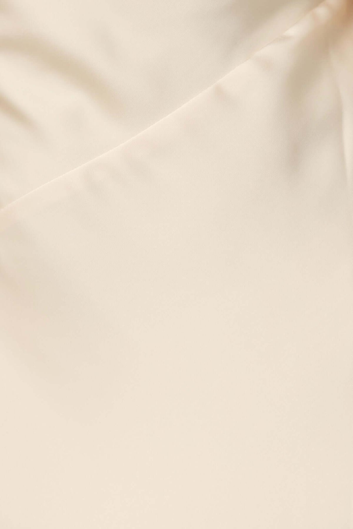 Close-up of soft satin fabric in light beige, showcasing smooth texture for the Ronnie Maxi Dress by Amaroso Bridal.