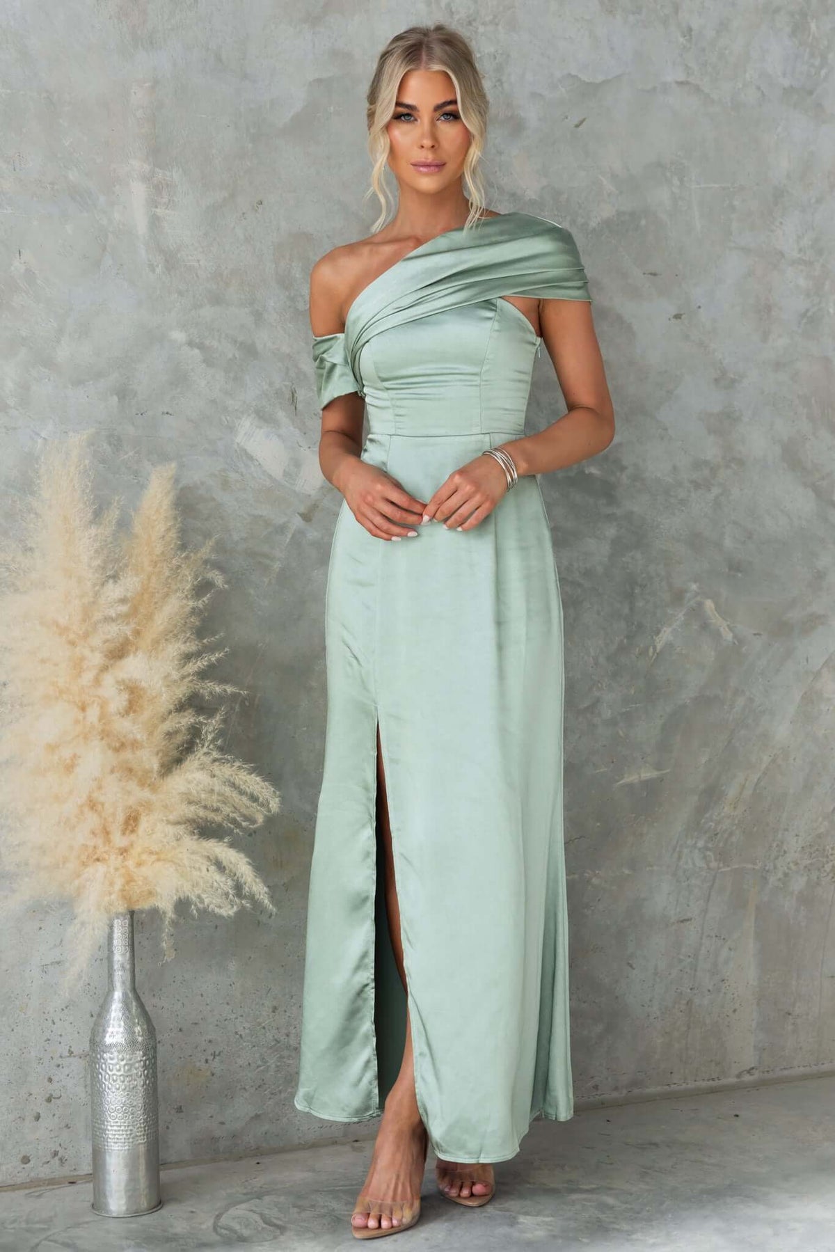 Model wearing a Sonnet Maxi Dress in a soft green shade with asymmetric neckline and side split.