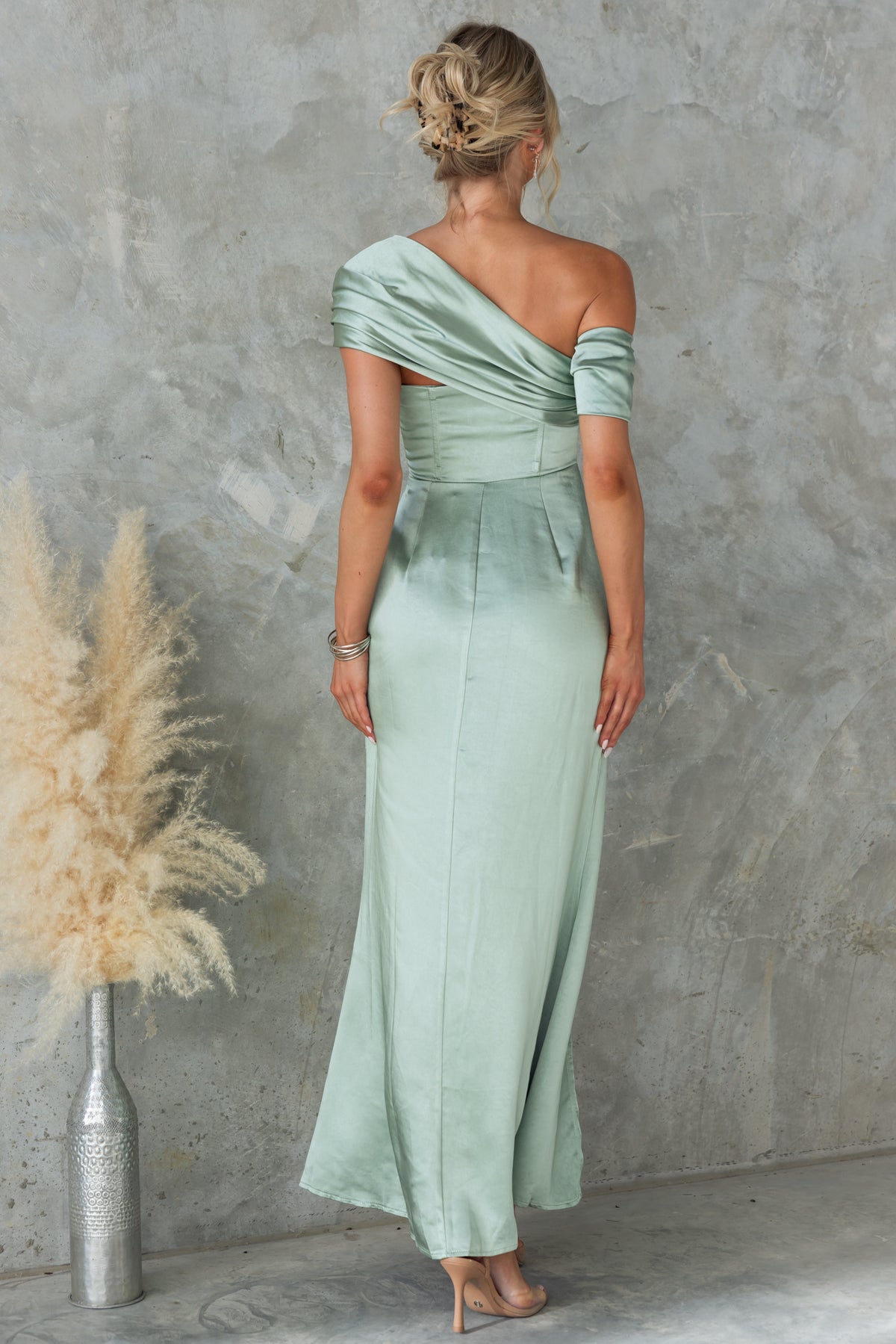 Back view of the Sonnet Maxi Dress in satin green, featuring asymmetric neckline and side split, perfect for formal occasions.