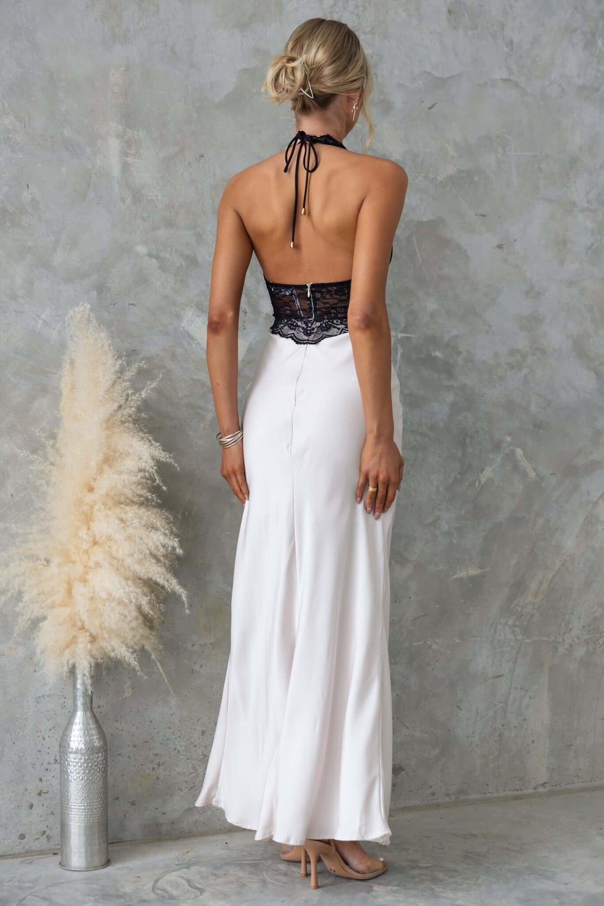 Back view of the Sonrisa Maxi Dress featuring a lace bust, satin finish, and tie neckline in soft hues.