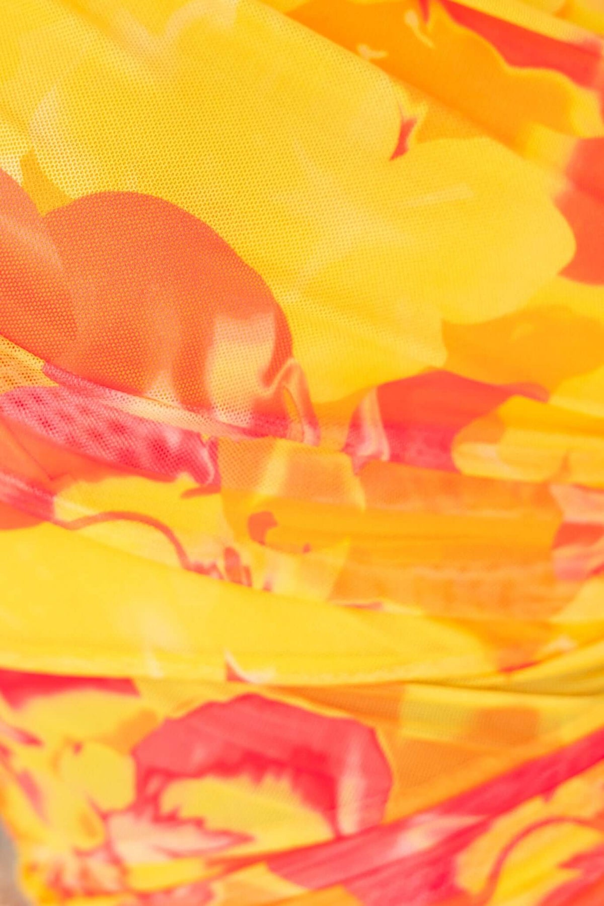 Close-up of vibrant yellow and orange floral mesh fabric of the Sundara Maxi Dress, showcasing its texture and colors.