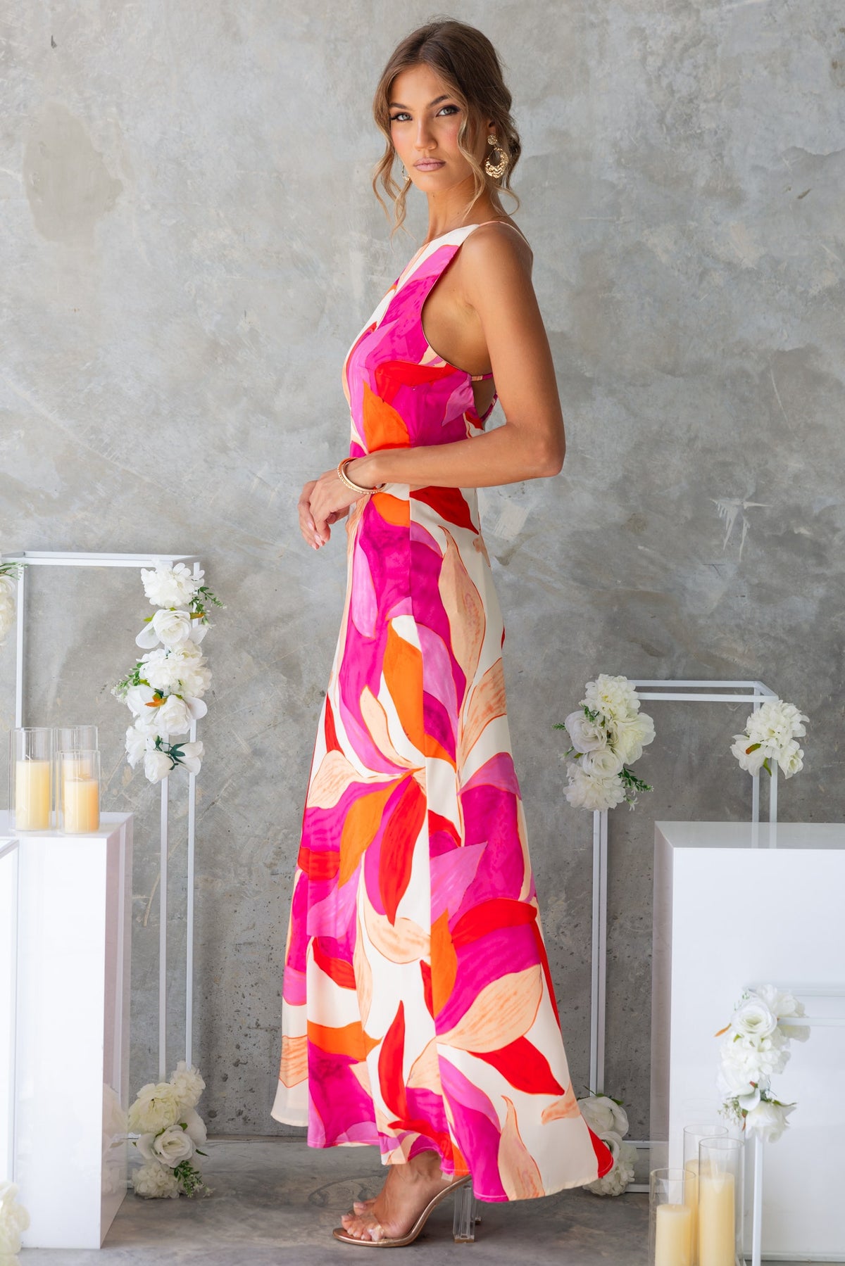 Model showcasing the Temptress Maxi Dress with a vibrant floral pattern and high neckline, perfect for summer events.