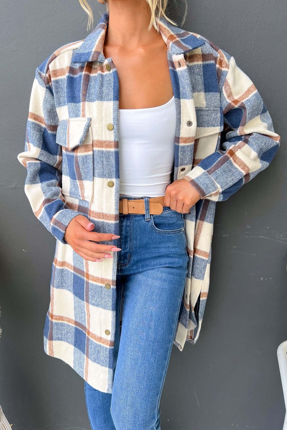 Model wearing a stylish Torres shacket with pockets, blue and beige plaid pattern, paired with a white tank top and jeans.