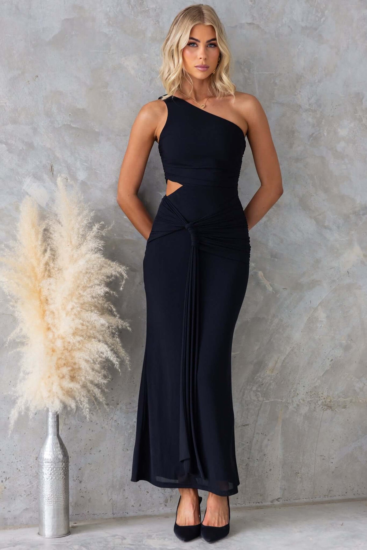 Elegant black ultra maxi dress with one-shoulder neckline and cut-out waist, perfect for special occasions.