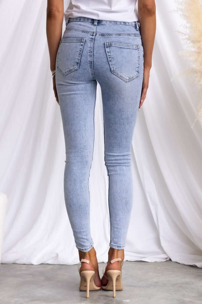 Woman wearing Under Cover Jeans, showcasing the back view of light blue skinny-fit denim with a mid-high waist.