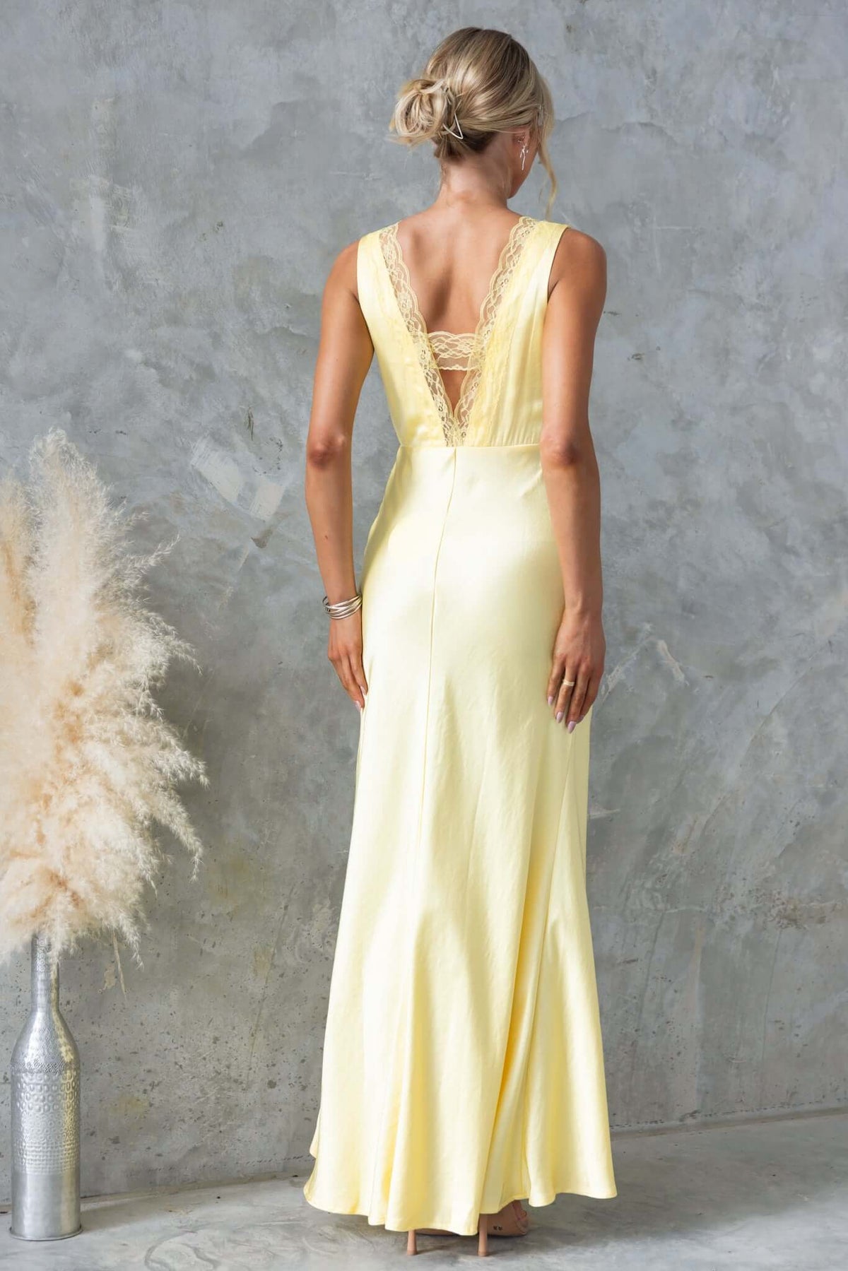 Back view of Uvira Maxi Dress in yellow with lace trim and V-neckline, perfect for formal events.