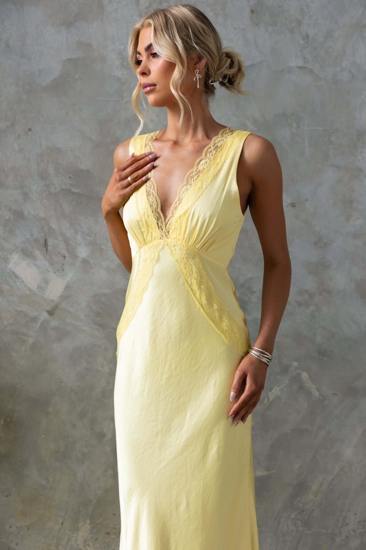 Uvira Maxi Dress in yellow satin, featuring a V-neckline and lace trim, elegantly styled with a side invisible zip.