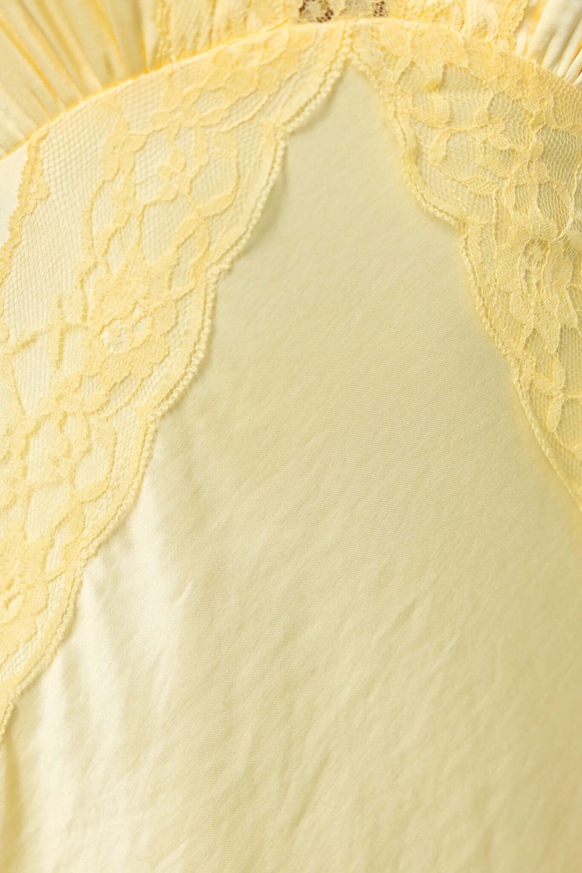 Close-up of Uvira maxi dress featuring soft fabric and delicate lace trim in a cheerful yellow color.