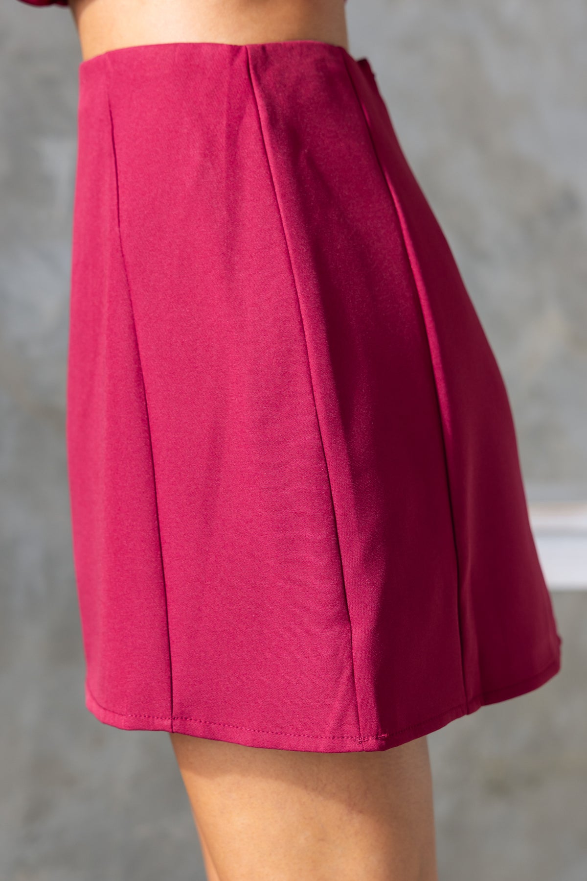 Varis Skirt in vibrant pink, displaying mid-high waist fit and side pleats, perfect for a stylish summer look.